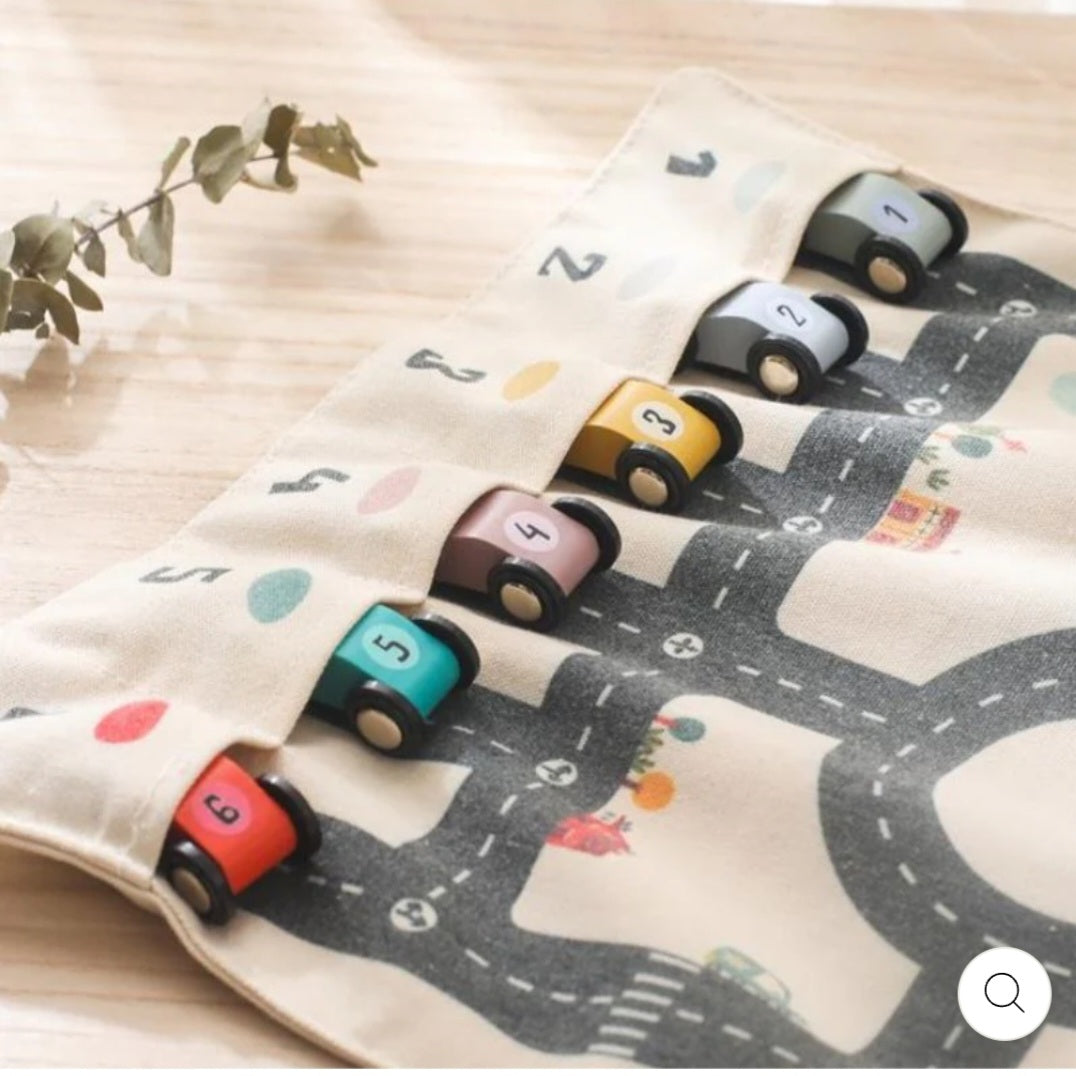 Double-sided, roll-up, canvas playmat with wooden cars.